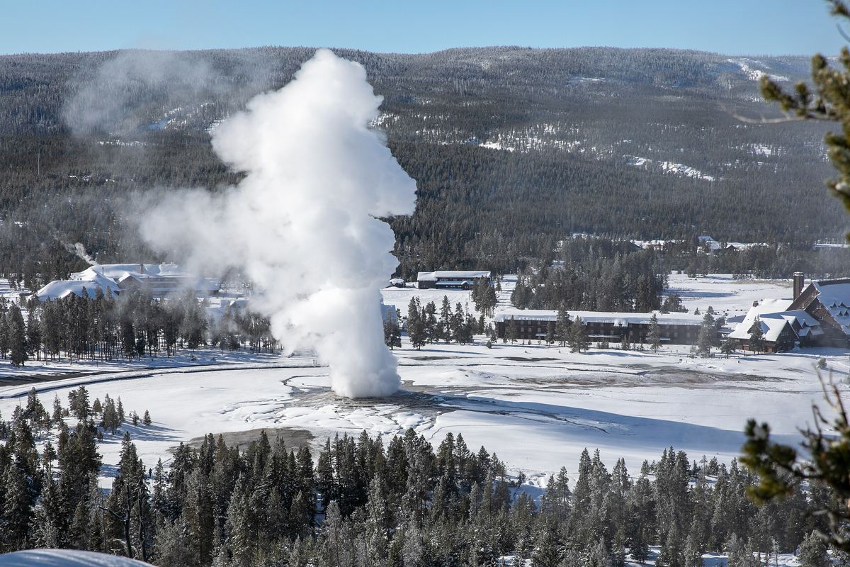 Old Faithful erupting above a snow-covered Upper Geyser Basin