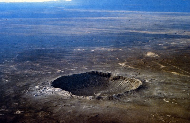 Aerial view of Meteor Crater, a deep round bowl in a flat Arizona plain